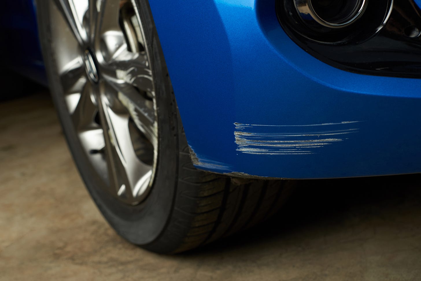 Blue sports car with a scrape on the front