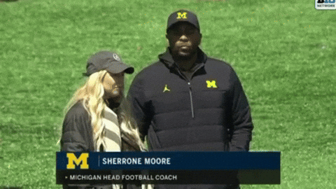Sherrone Moore on the field with his executive assistant.