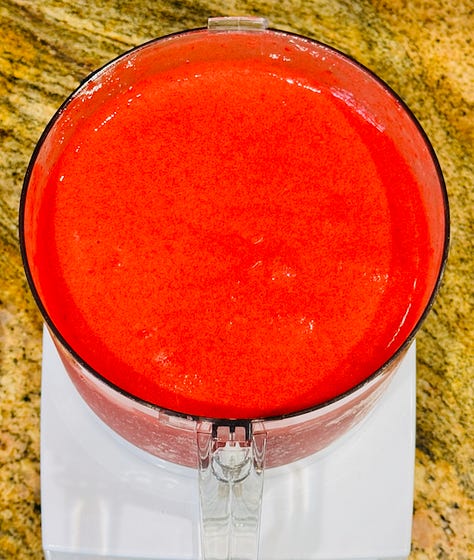 Homemade raspberry sorbet, deep pink and glossy, made with fresh raspberries, spun in a food processor, with sugar, lemon juice, sea salt, vanilla extract, and churned in an ice cream maker
