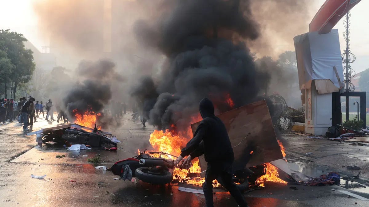 印尼首都雅加达街头爆发激烈示威抗争，抗争民众焚烧车辆和杂物。（美联社）