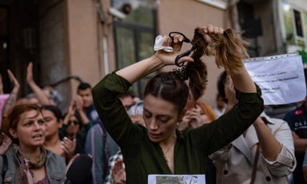 An Iranian woman living in Turkey, cuts her ponytail off during a protest outside the Iranian consulate in Istanbul on 21 September. An Iranian woman living in Turkey, cuts her ponytail off during a protest outside the Iranian consulate in Istanbul on 21 September.