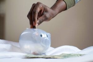 Hand dropping a coin into a piggybank