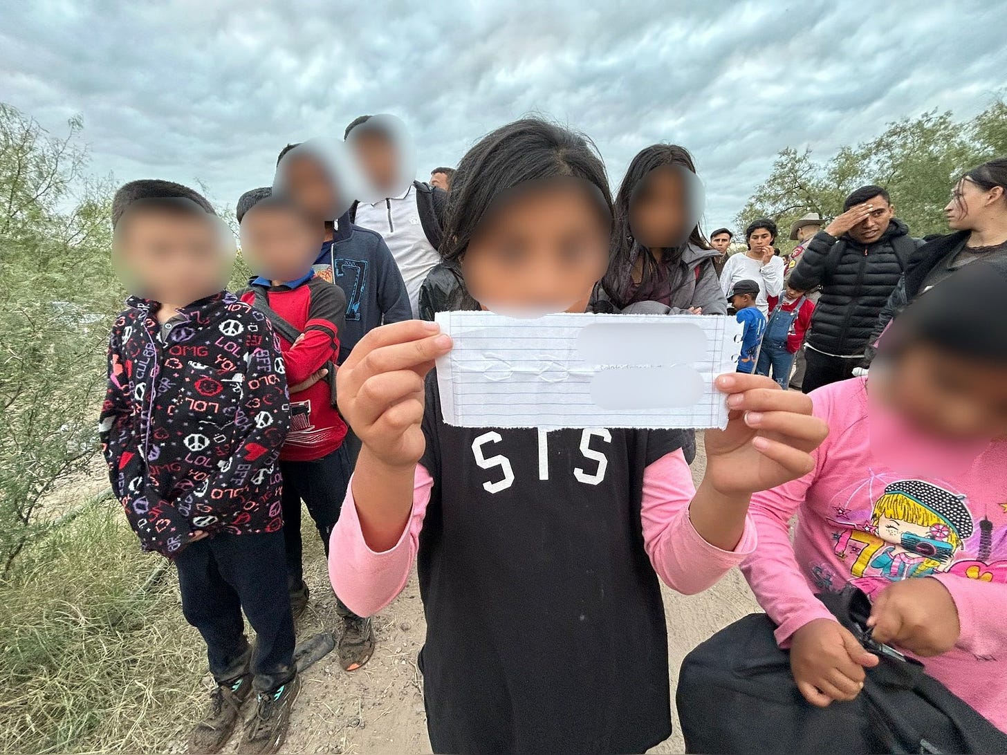 A child presents a paper with contact information of  a person in the US to Texas DPS Troopers in Maverick County in August of 2024. 57 unaccompanied minor migrant children were found in a group of 204 people who illegally crossed the Rio Grande with the aid of Mexican Cartel “guides.” (Texas Dept. of Public Safety image)