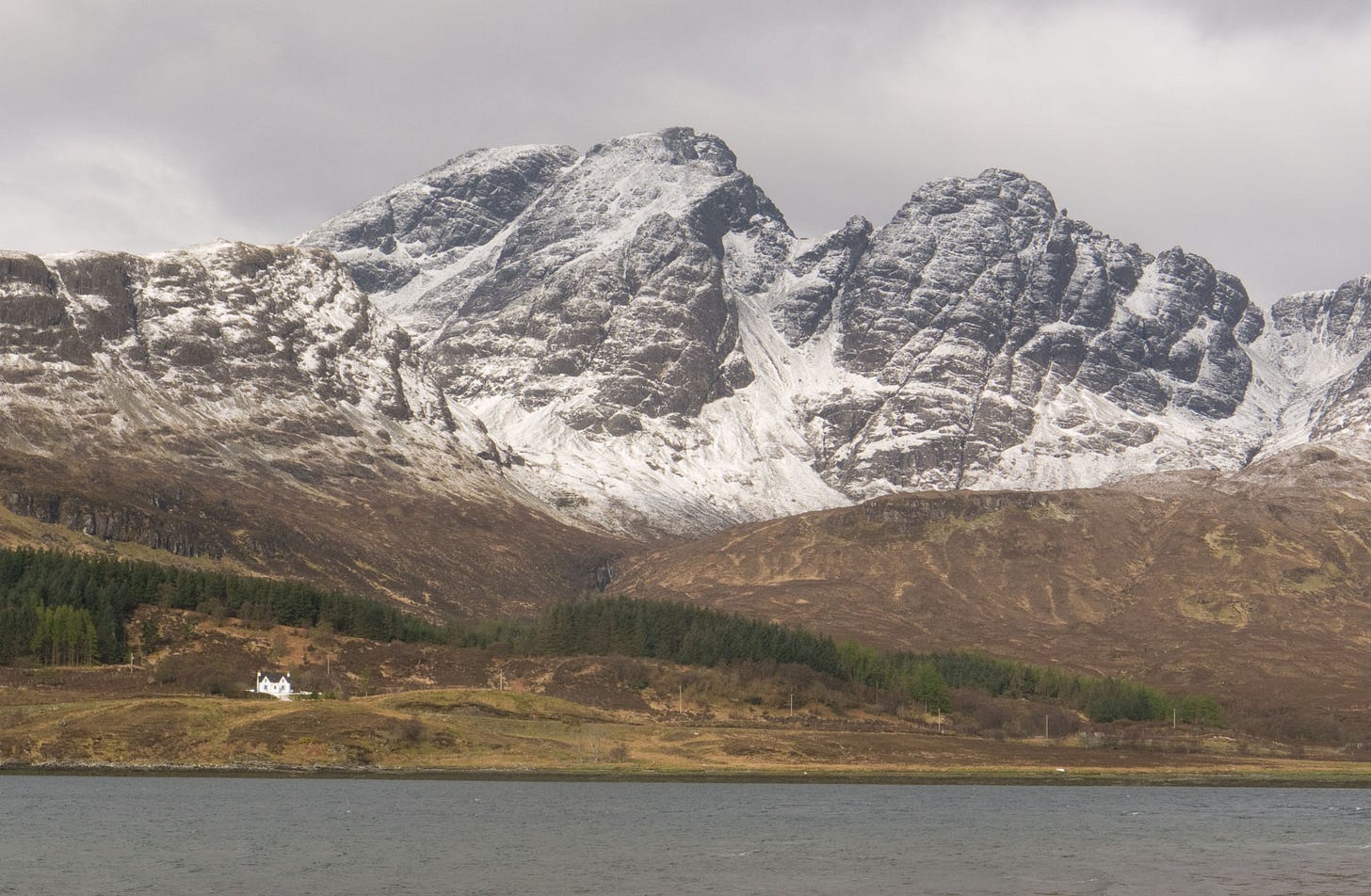 snowy rocky mountain, white lodge below