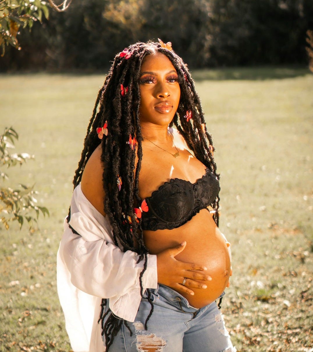 a pregnant woman in ripped jeans and a black bra a pregnant woman in ripped jeans and a black bra