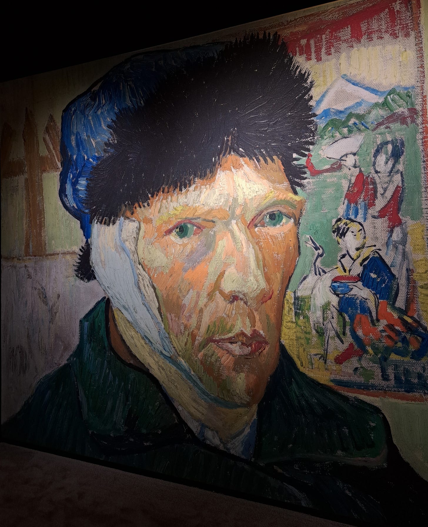 A projection of Van Gogh's painting, Self-Portrait with Bandaged Ear. In the painting Van Gogh wears a blue fur-trimmed hat and a heavy blue coat. 
