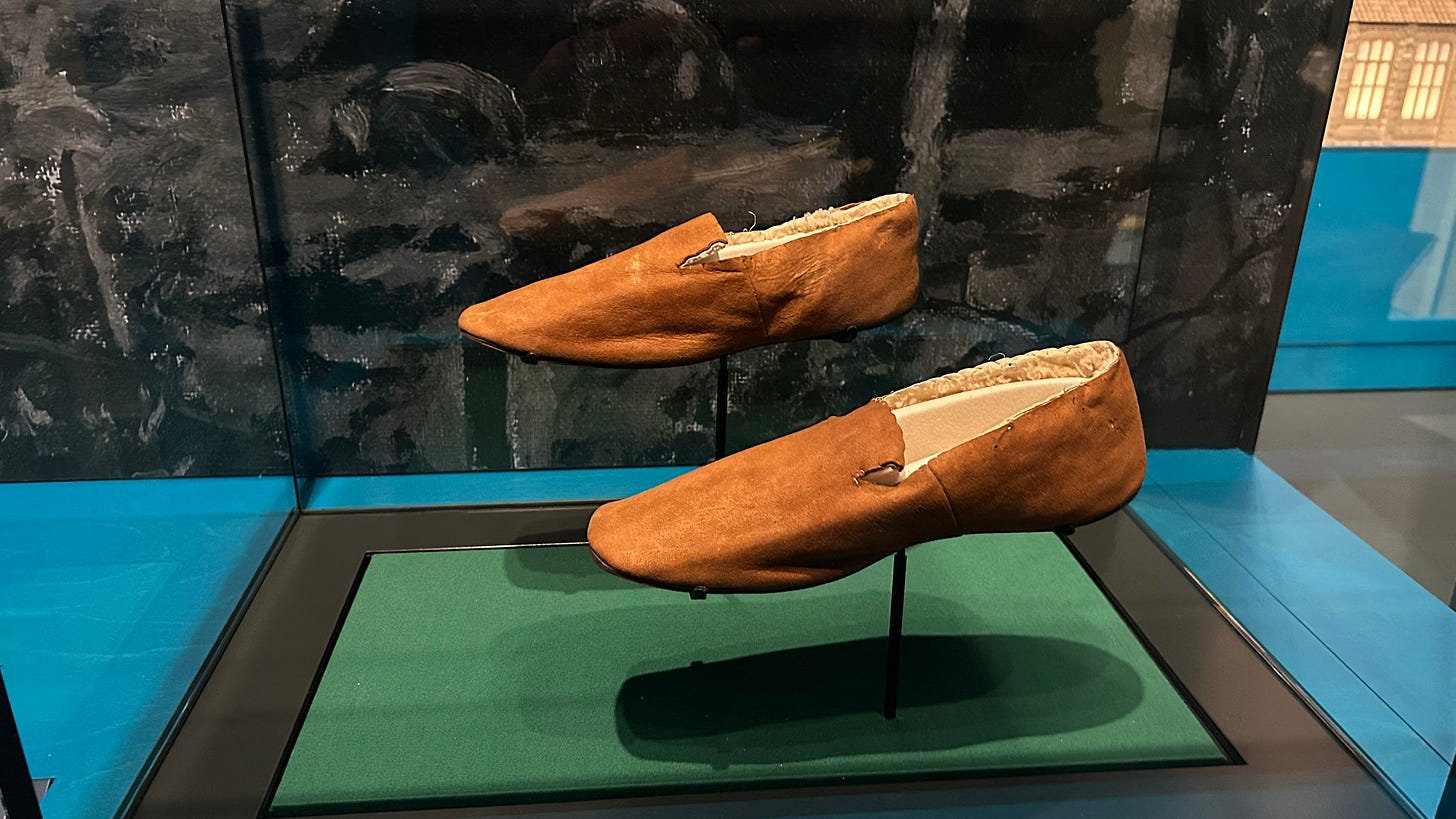 A pairof brown sheepskin slippers in a display case. Made by Clarks these slippers launched the company into footwear. A pairof brown sheepskin slippers in a display case. Made by Clarks these slippers launched the company into footwear.