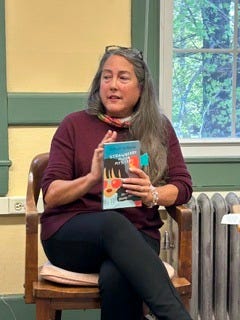 woman holding book and talking