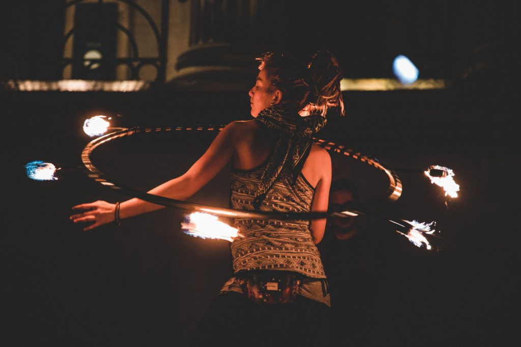 Woman juggling fire with hula-hoop