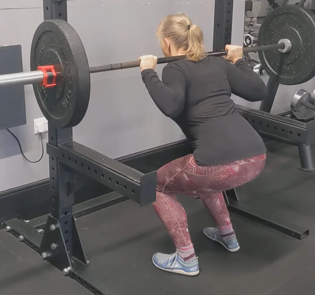 Image of Andrea demonstrating a barbell back squat Image of Andrea demonstrating a barbell back squat