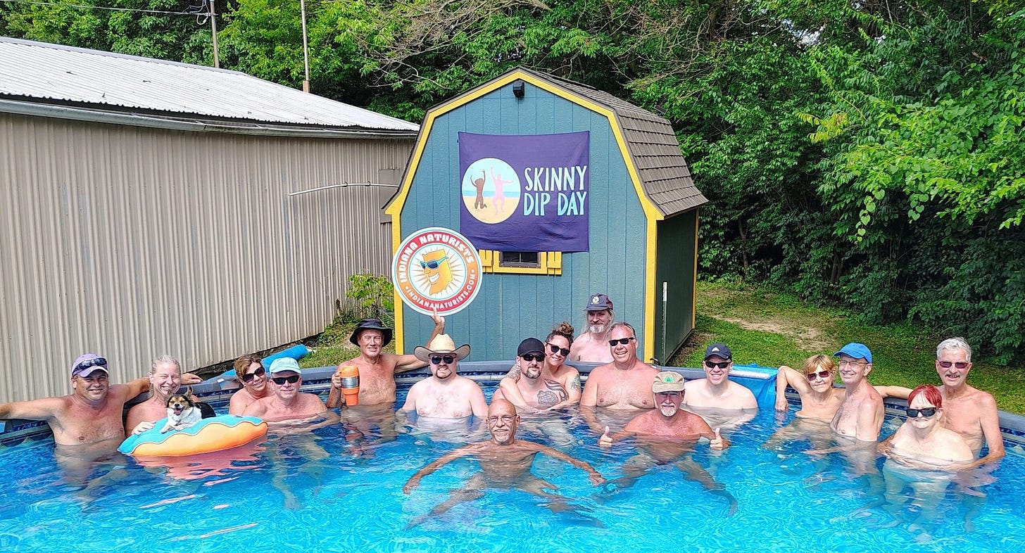 A group of nude people smile and pose in a backyard pool in front of a shed decorated with a Skinny Dip Day banner. A small dog floats on an inflatable pool toy. The group includes members of the Indiana Naturists. A group of nude people smile and pose in a backyard pool in front of a shed decorated with a Skinny Dip Day banner. A small dog floats on an inflatable pool toy. The group includes members of the Indiana Naturists.