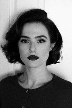 This may contain: a black and white photo of a woman with dark lipstick