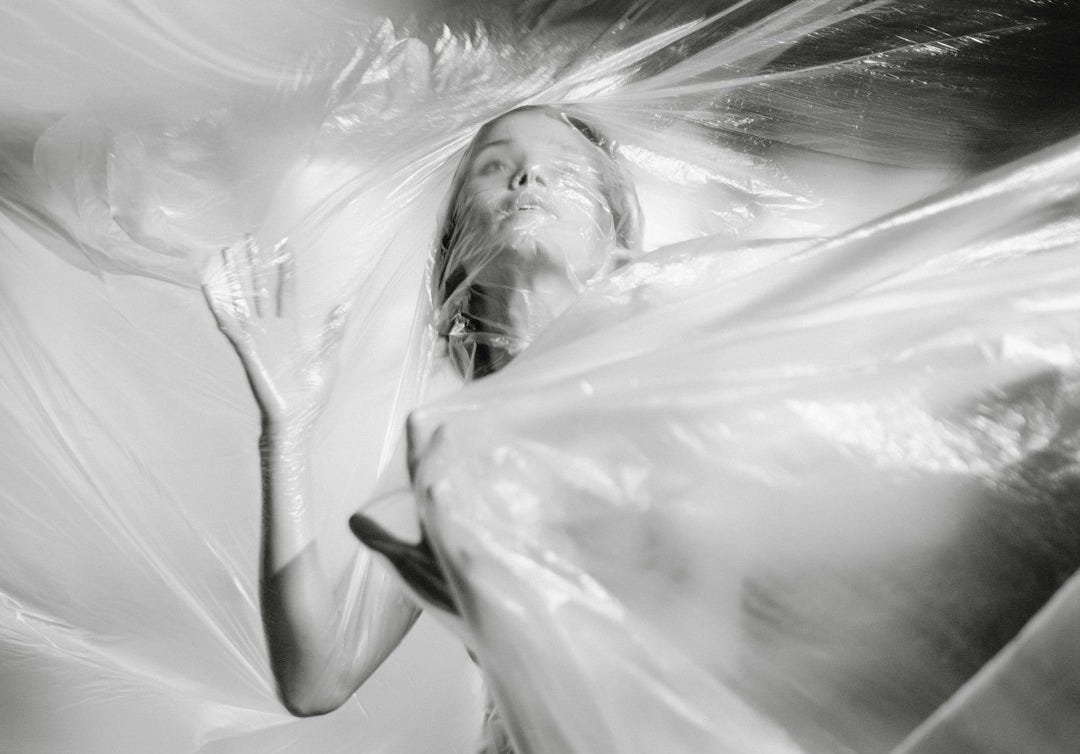 grayscale photography of woman covered in plastic
