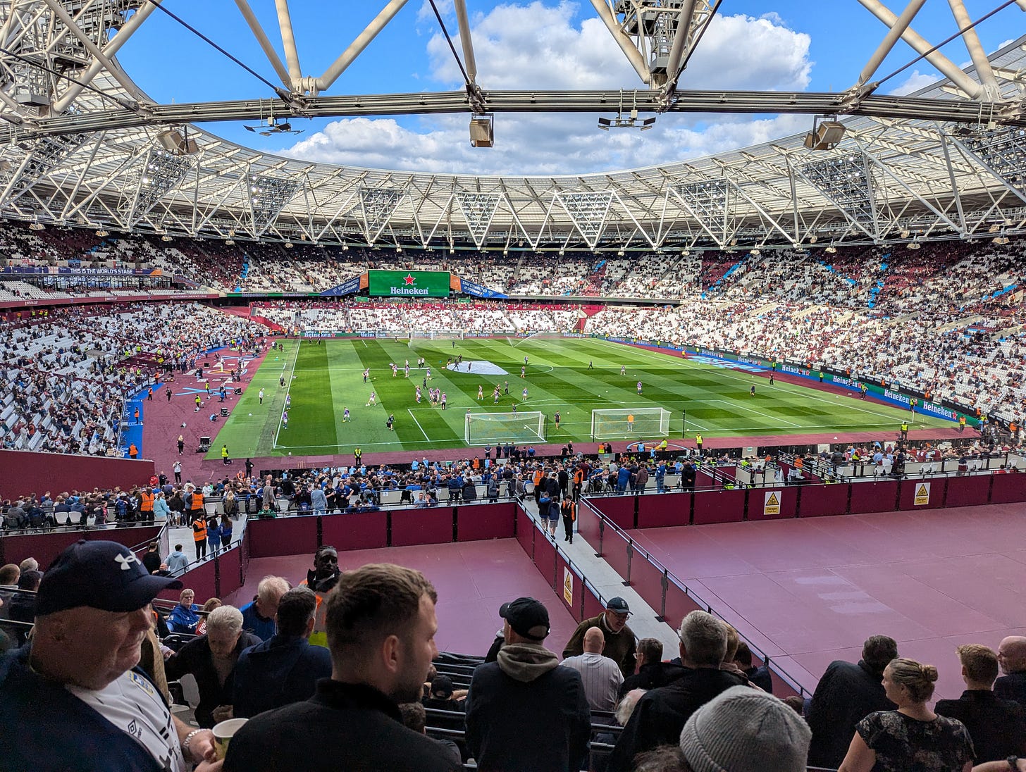 View from the upper tier of the South Stand at the London Stadium. The 20-30 metres in front of the stand is empty space, painted claret. Way down below is the lower tier full of the other Ipswich fans.