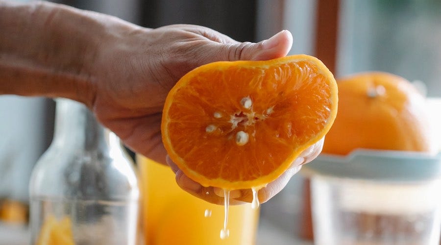 Squeezing juice from an orange Squeezing juice from an orange