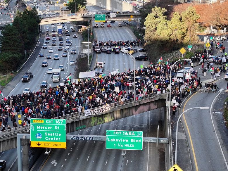 Demonstrators demanding a cease-fire in the Israel-Hamas war block northbound traffic on Interstate 5 in Seattle, between Pine Street and just south of Denny Way, on Saturday, Jan. 6. (Karen Ducey / The Seattle Times)