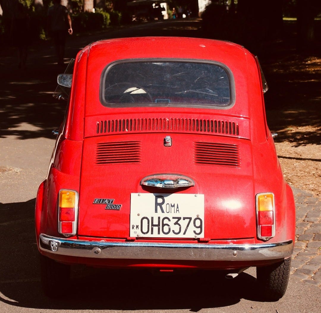 red Citroen 2CV on road red Citroen 2CV on road