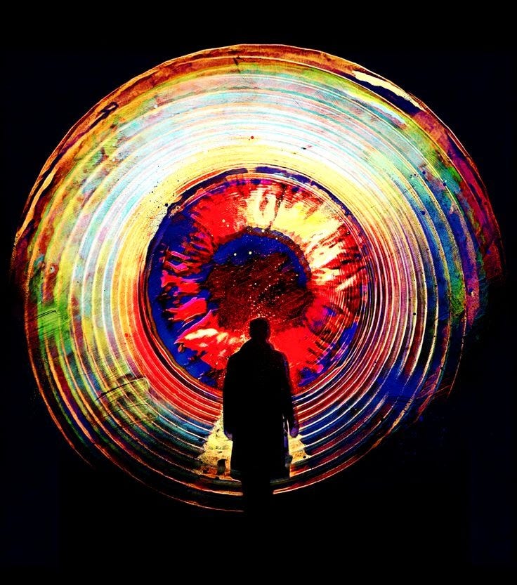This may contain: a man standing in front of a colorful wheel with the words 10 11 17 on it