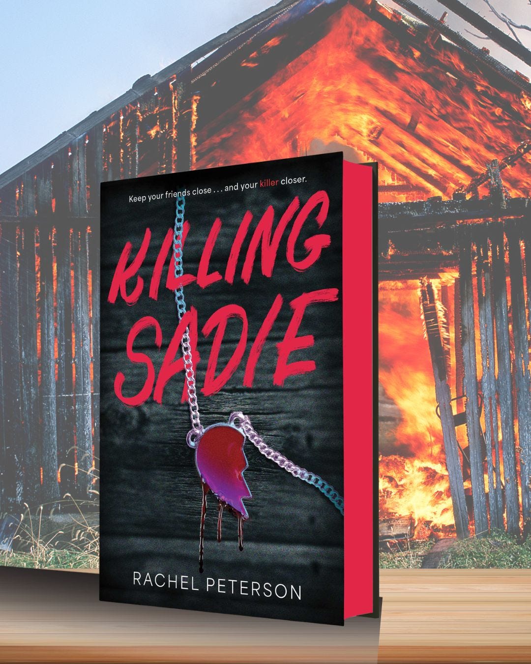 Book "Killing Sadie" on a table in front of a burning barn