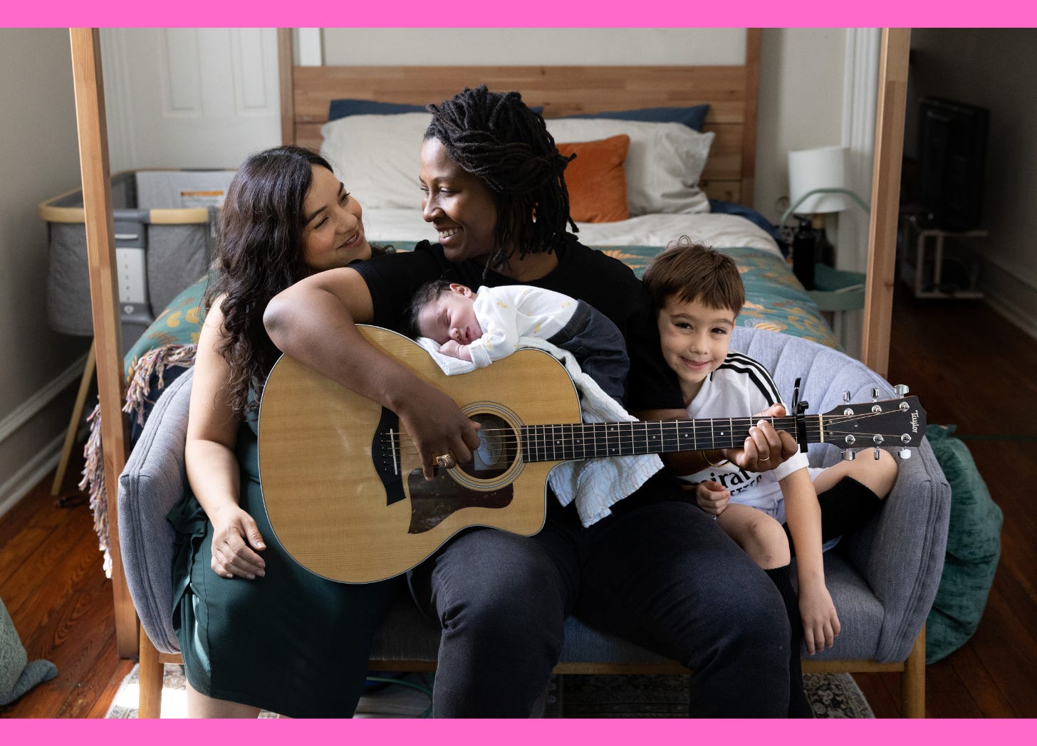 Family portrait, left to right: woman sitting, woman with guitar, newborn baby on guitar, little boy smiling.