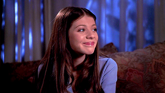 A GIF of Michelle Trachtenberg as Dawn Summers in "Buffy the Vampire Slayer." She smiles.