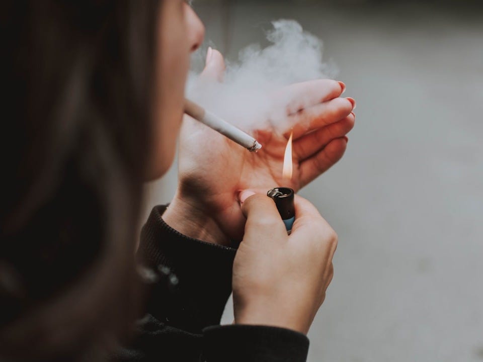 woman lights her cigarette with lighter woman lights her cigarette with lighter