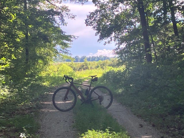 A bicycle parked on a dirt road

AI-generated content may be incorrect.