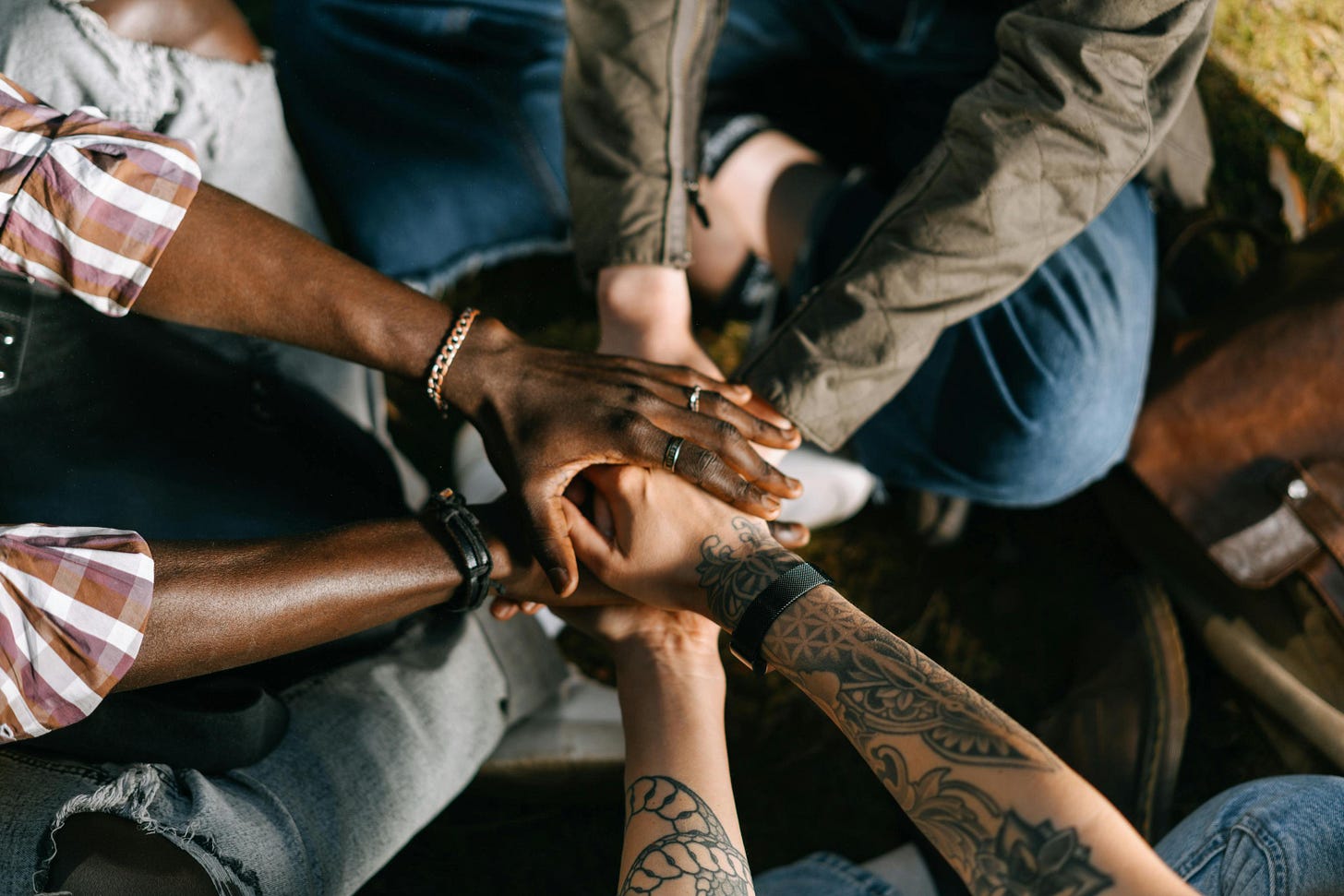 Photo of hands stacked together in a team huddle