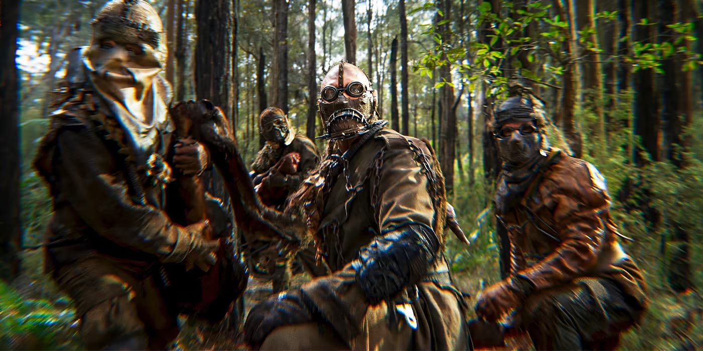 Four raiders in the idyllic green place harvesting the meat of a horse. They are turning to stare at the camera as if alerted to danger.