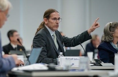 A person in a suit speaking to a group of people

AI-generated content may be incorrect.