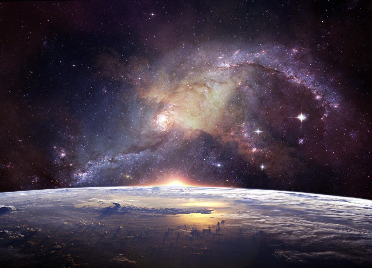 Outer space scene showing the curve of Earth with sunlight peeking over the horizon and a large galaxy surrounded by stars in the background.