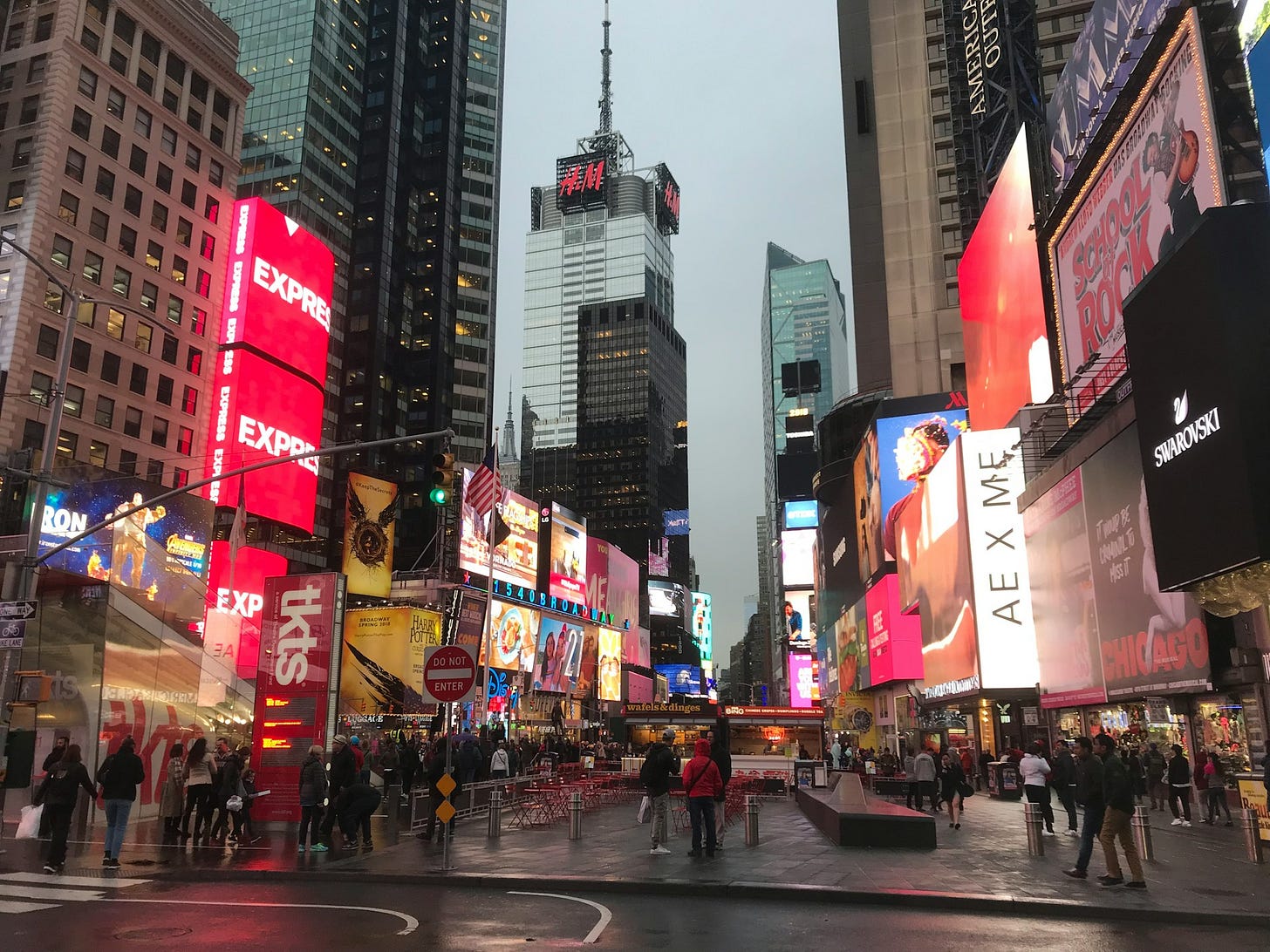 Bright billboards and digital ads light up a crowded city street in Times Square, symbolizing information overload and competing brand messages. Photo by Guido Coppa on Unsplash