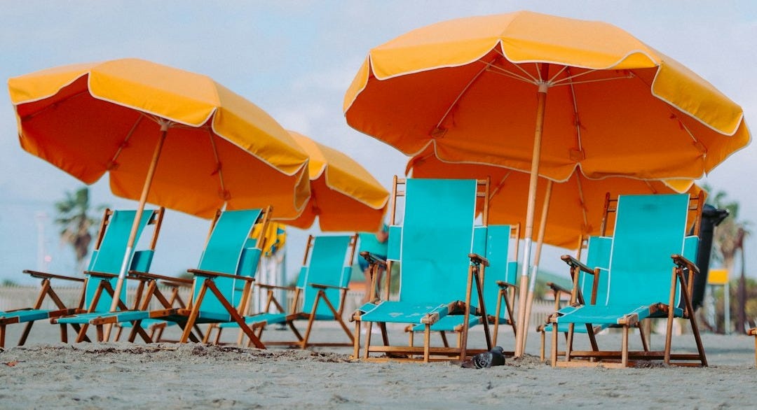 closeup photo of lounger chairs and beach umbrellas closeup photo of lounger chairs and beach umbrellas
