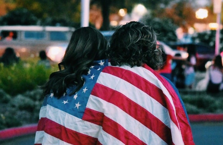 woman and man covered USA flag woman and man covered USA flag
