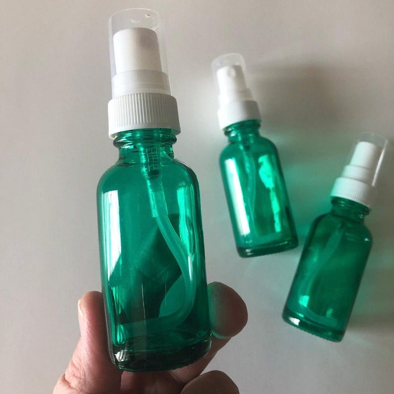 1 oz green glass spray bottle with white color spray top and clear cap. perfect for essential oil blends