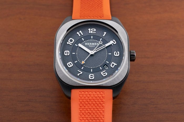 The Hermès H08 with DLC-coated titanium case and orange rubber strap. The Hermès H08 with DLC-coated titanium case and orange rubber strap.