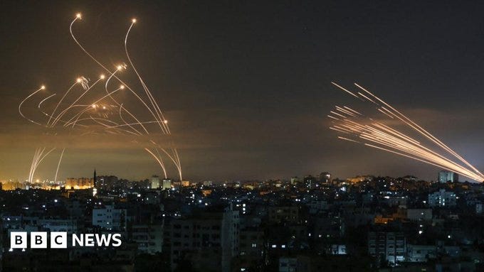 Rockets are seen in the night sky fired towards Israel from Beit Lahiya in the northern Gaza Strip (14 May 2021)