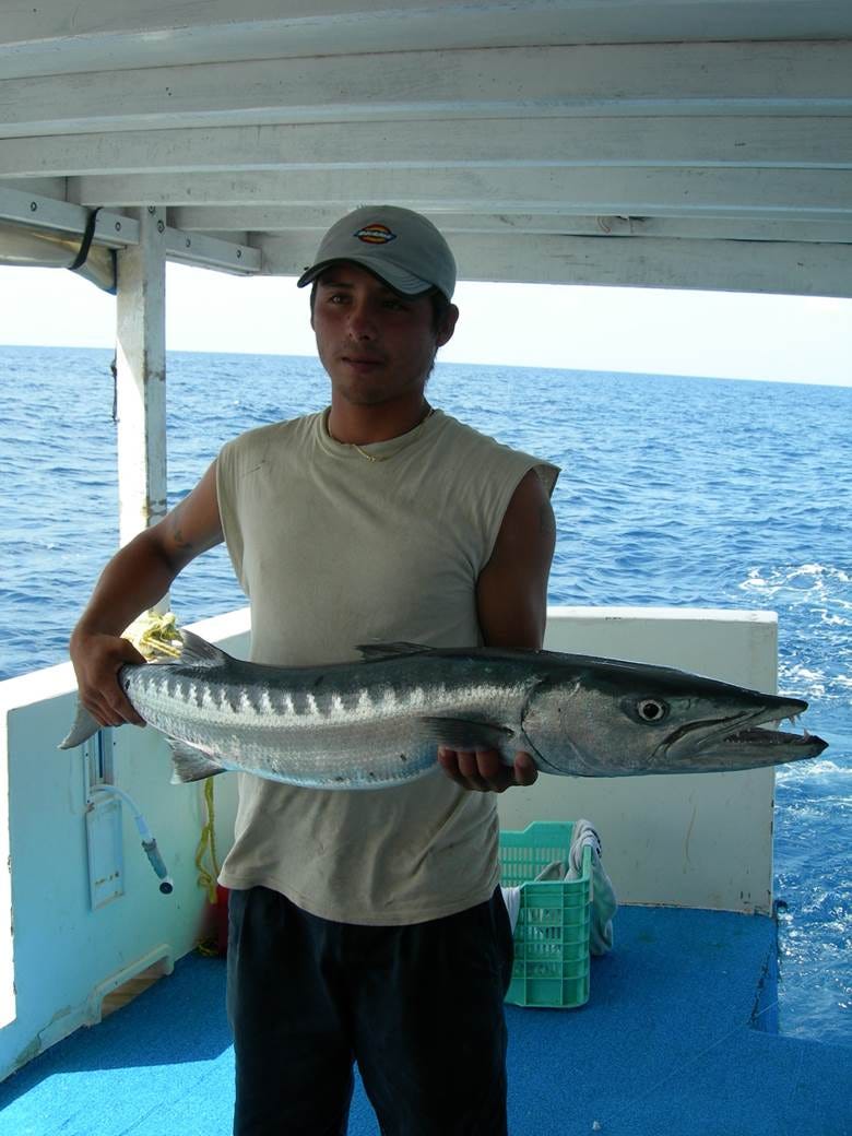 A person holding a fish

Description automatically generated