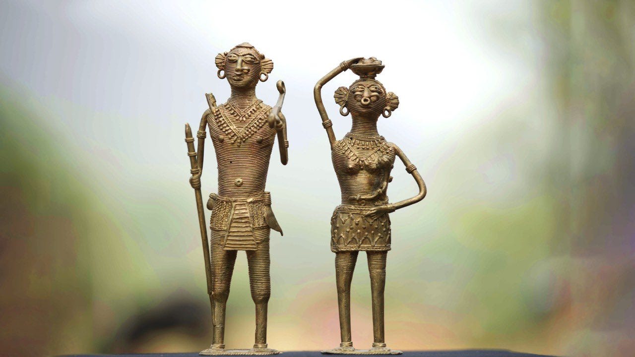 two bronze figurines standing next to each other
