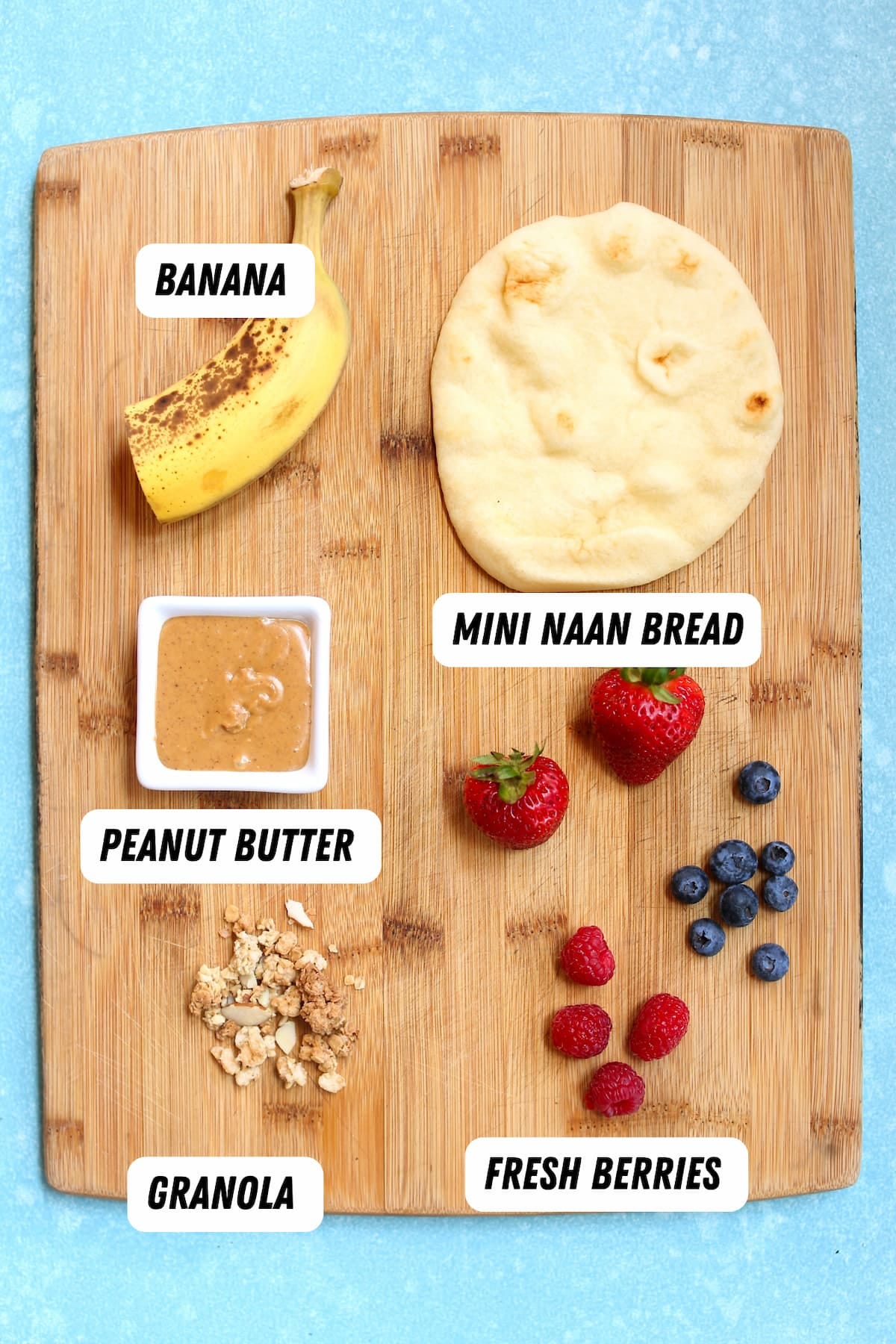 a cutting board with naan bread and other ingredients.