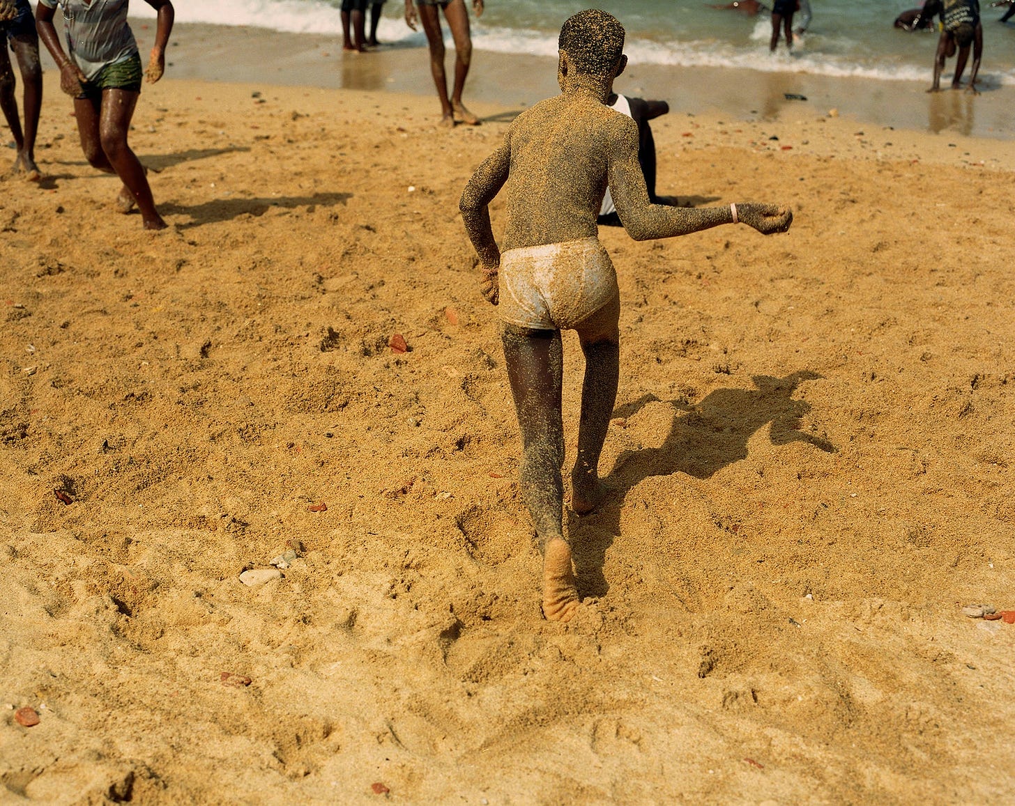 Image may contain Ground Human Person Skin Clothing Apparel Back Outdoors Nature and Sand