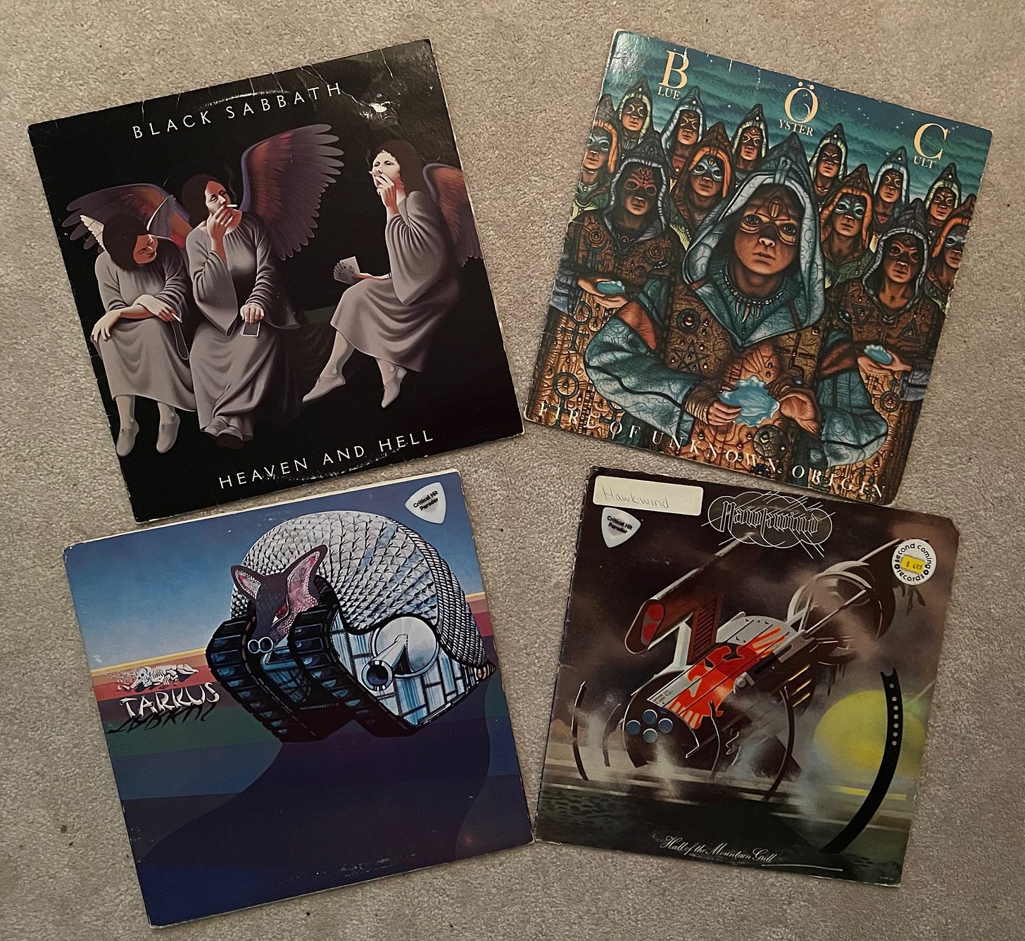 Four albums: Heaven and Hell by Black Sabbath, Fire of Unknown Origin by Blue Oyster Cult, Tarkus by Emerson, Lake and Palmer, and Hall of the Mountain Grill by Hawkwind