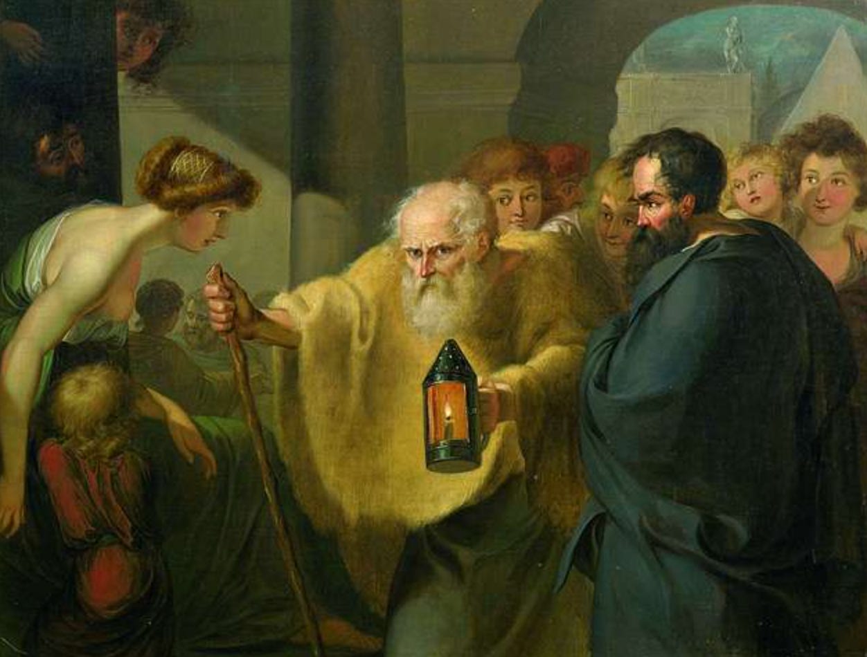 Diogenes, a balding man with a white beard, leans on a walking stick and carried a lit lantern through a crowd of people, some of whom gawk at him.