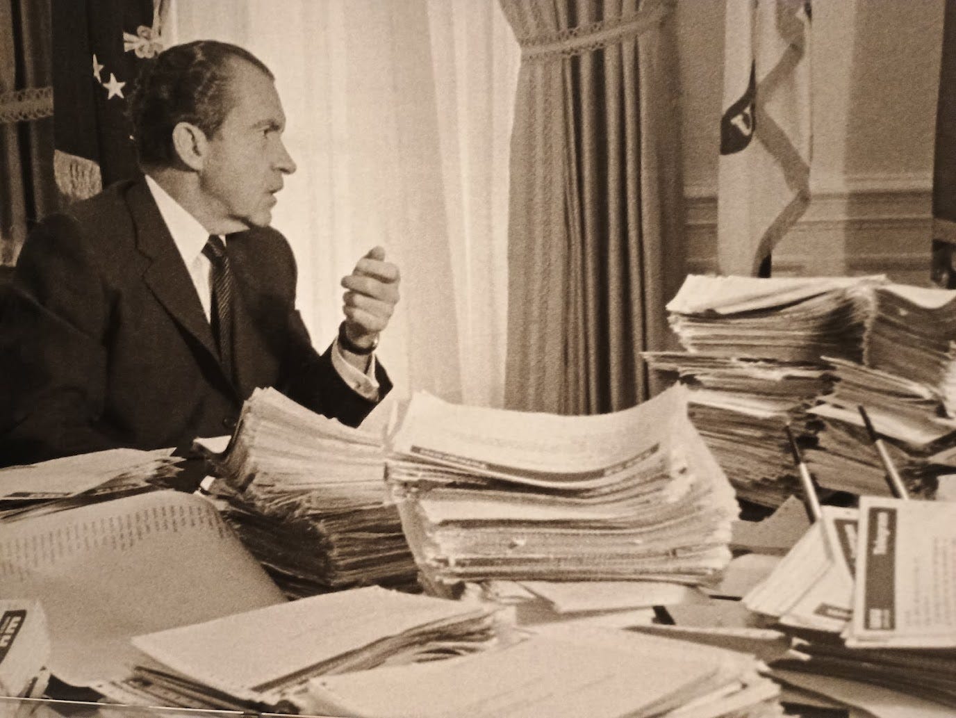 Nixon in Oval Office in conversation withaide H.R. Haldeman (not in photo), with piles of telegrams stacked on his desk