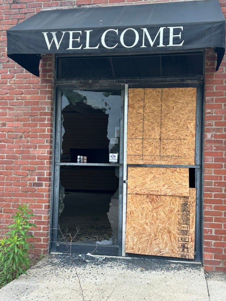 A brick building with a sign and a door

AI-generated content may be incorrect.