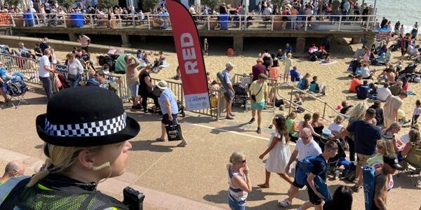 Police officer surveys a crowded beach