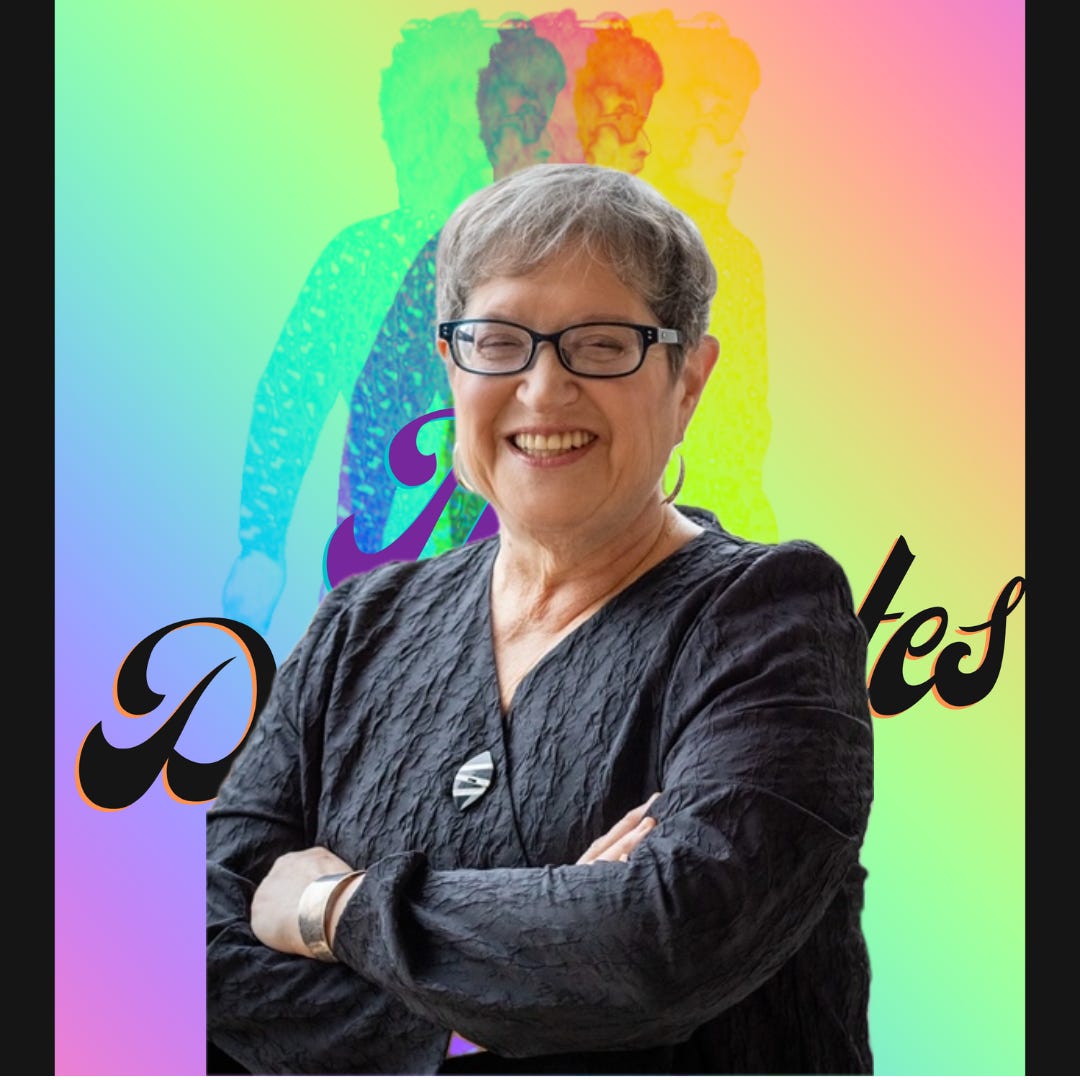 Photo of Roberta rakove with her arms folded standing in front of The Dylantantes logo.