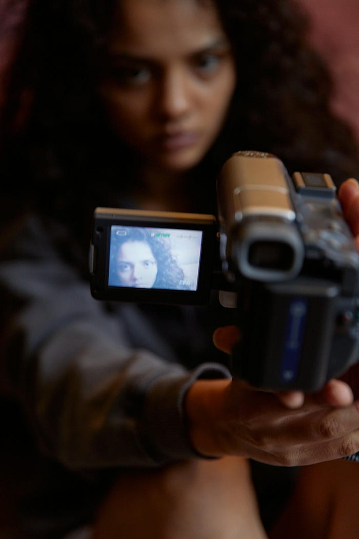 Woman filming herself with a recorder, holding it out to take a selfie