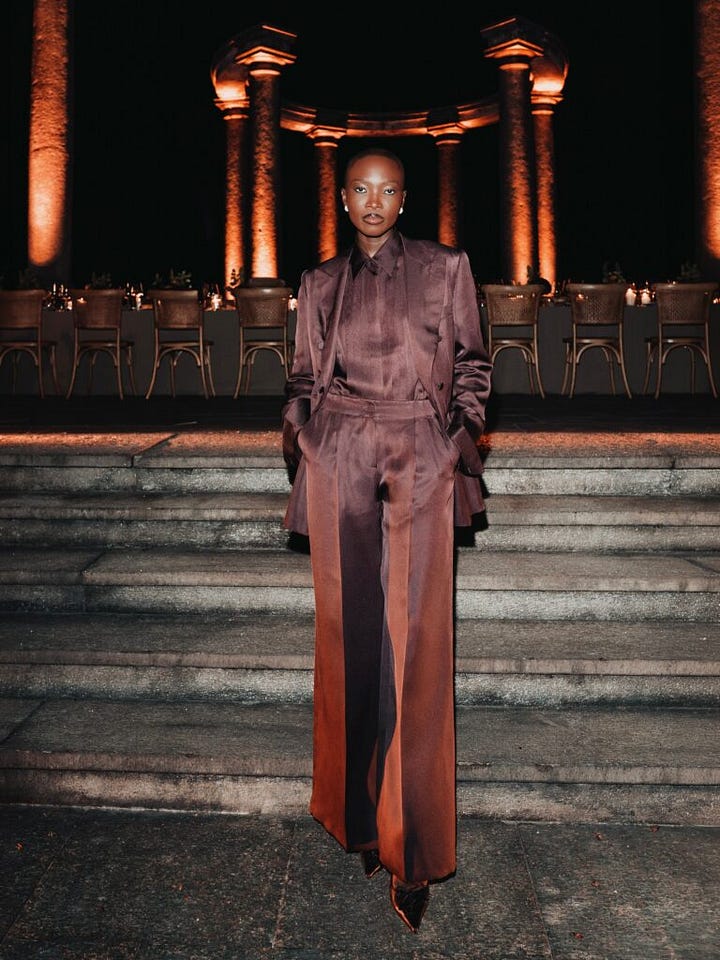 Two guests wearing dark pinstripe and brown tailored suits at Brioni’s evening event.