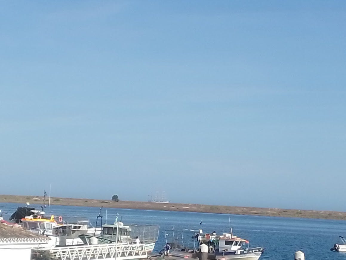 As is typical of my pictures--there's a ton of BLUE. Three quarters of the picture is sky. Most of the rest is the channel. Splitting the two is the Ria formosa, a barrier island. Fishing boats in the foreground and very, very faintly in the middle of the picture is a three masted barque, the Sagres III. 